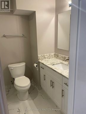 Vaughan (Kleinburg) apartment for rent - A white toilet in a small bathroom with a marble counter top.
