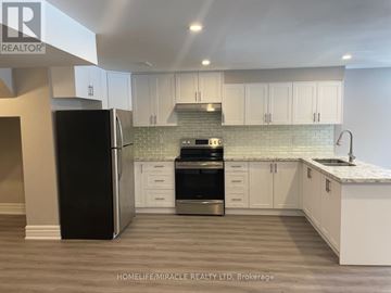 Vaughan (Kleinburg) apartment for rent - A kitchen with white cabinets and a black fridge.