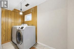 Toronto (Pleasant View) apartment for rent - A washing machine is in a small room with wooden walls.