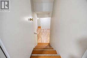 Toronto (Pleasant View) apartment for rent - A hallway with a wooden staircase leading to a landing.