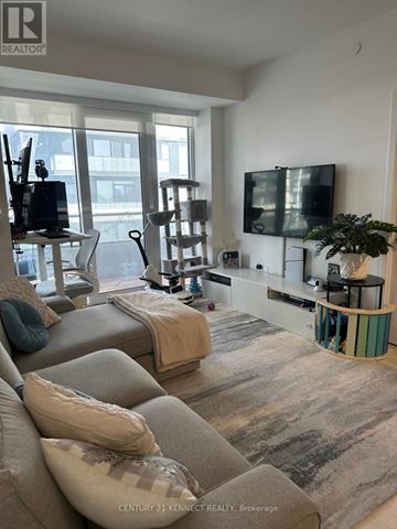 Richmond Hill (Langstaff) condo for rent - A living room with a grey couch and a television on the wall.
