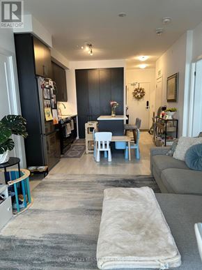 Richmond Hill (Langstaff) condo for rent - A living room with a grey couch and a white rug.