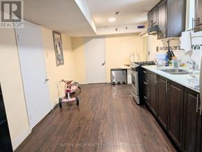Toronto (Mount Olive-Silverstone-Jamestown) apartment for rent - A kitchen with dark wood floors and white appliances.