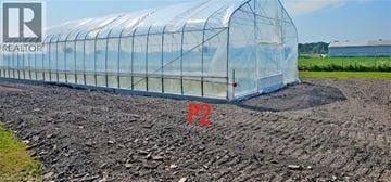Stoney Creek apartment for rent - A greenhouse with a transparent cover is situated in a field.