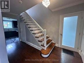 Ottawa apartment for rent - A hallway with a staircase and a chandelier.