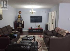 Toronto (Eglinton East) condo for rent - A living room with a brown couch, a coffee table, and a flat screen TV.