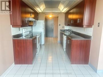 Toronto (Agincourt South-Malvern West) condo for rent - A kitchen with wooden cabinets and a tile floor.
