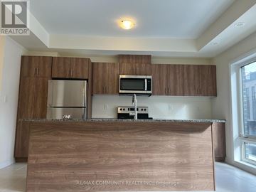 Toronto (Malvern) townhouse for rent - A kitchen with brown cabinets and a wooden counter.