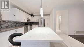 Markham (Village Green-South Unionville) apartment for rent - A modern kitchen with a marble island and a refrigerator.
