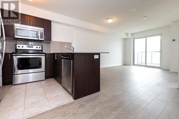 Toronto (Dovercourt-Wallace Emerson-Junction) condo for rent - A modern kitchen with dark brown cabinets and stainless steel appliances.