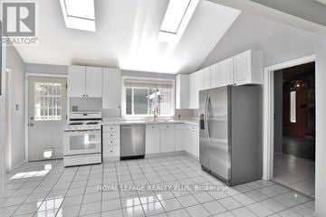 Oakville (Fd Ford) apartment for rent - A kitchen with white cabinets and appliances is on the market with Royal LePage Realty Plus.