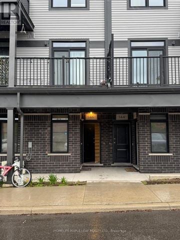 Kitchener townhouse for rent - A two story building with a balcony and a bicycle parked in front.