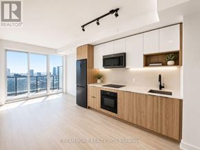Toronto (Regent Park) condo for rent - A modern kitchen with wooden cabinets and a view of the city.