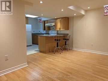Toronto (West Humber-Clairville) apartment for rent - A kitchen with wooden floors and a counter with two barstools.