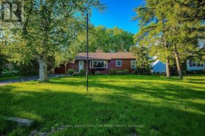 Welland (N. Welland) apartment for rent - A house with a red roof and white trim is surrounded by trees and grass.