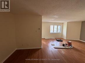 Toronto (Kennedy Park) townhouse for rent - A room with wooden floors and a window is being prepared for painting.