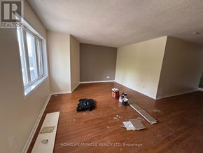 Toronto (Kennedy Park) townhouse for rent - A room with wooden flooring and paint cans on the floor.