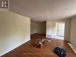 Toronto (Kennedy Park) townhouse for rent - A room with wooden flooring and a white door is shown.