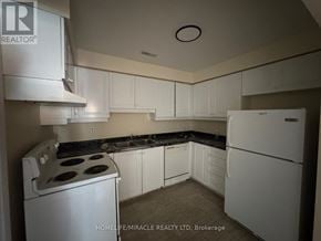 Toronto (Kennedy Park) townhouse for rent - A kitchen with white appliances and cabinets.