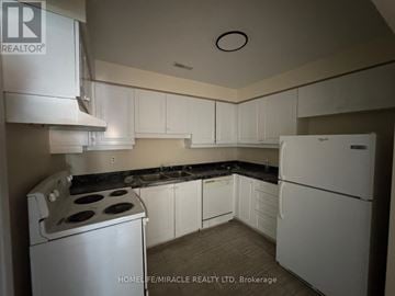 Toronto (Kennedy Park) townhouse for rent - A kitchen with white appliances and cabinets.