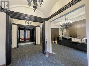 Toronto (Church-Yonge Corridor) condo for rent - A hallway with a chandelier and a sign that says Century 21 Kennec