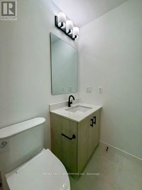 Burlington (Alton) condo for rent - A bathroom with a toilet, sink, and mirror.