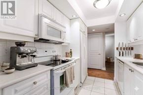 Toronto (Willowdale East) condo for rent - A white kitchen with a microwave and oven.
