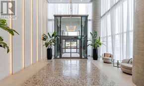 Vaughan (Vaughan Corporate Centre) condo for rent - A modern hallway with a glass door and a tiled floor.