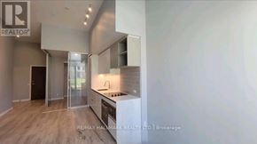 Vaughan (Vaughan Corporate Centre) condo for rent - A modern kitchen with a glass door cabinet and a wooden floor.