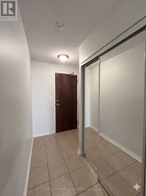 Mississauga (Central Erin Mills) condo for rent - A hallway with a door and a glass door.