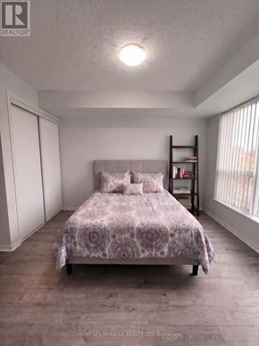 Mississauga (Central Erin Mills) condo for rent - A bedroom with a bed, a bookshelf, and a window.