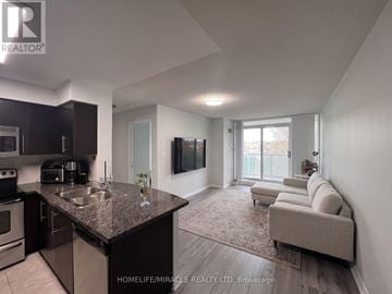 Mississauga (Central Erin Mills) condo for rent - A modern kitchen with dark brown cabinets and a granite countertop.