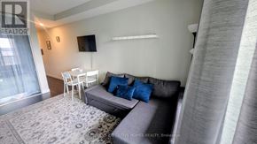 Hamilton (Central) condo for rent - A living room with a grey couch and a white table.