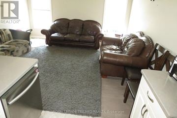 St. Thomas apartment for rent - A brown leather couch and chair in a living room.