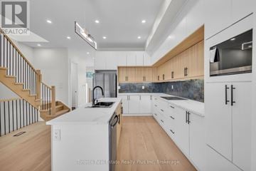 Toronto (Briar Hill-Belgravia) apartment for rent - A modern kitchen with wooden cabinets and a staircase.