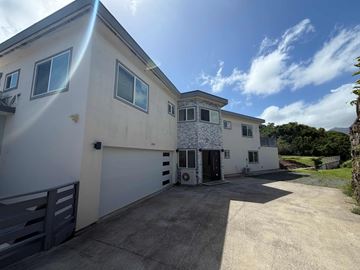 Kailua apartment for rent - A white house with a grey roof and a garage door.