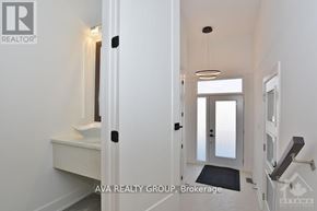 Ottawa apartment for rent - A hallway with a light on the wall and a door on the left.