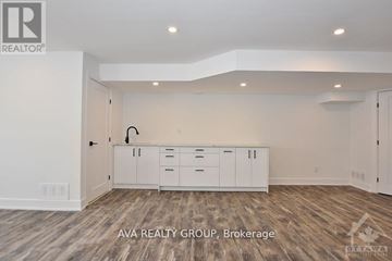 Ottawa apartment for rent - A white kitchen with wood flooring and cabinets in a real estate brokerage.