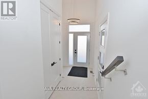 Ottawa apartment for rent - A hallway with a black mat on the floor and a light fixture above it.
