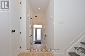 Ottawa apartment for rent - A hallway with a door on the left and a staircase on the right.