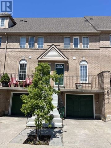 Mississauga (Hurontario) townhouse for rent - A house with a green door and a tree in front.