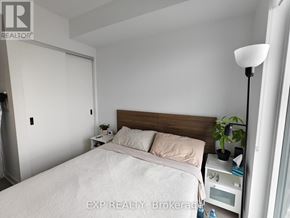Toronto (Islington-City Centre West) condo for rent - A bedroom with a bed, nightstand, and lamp.
