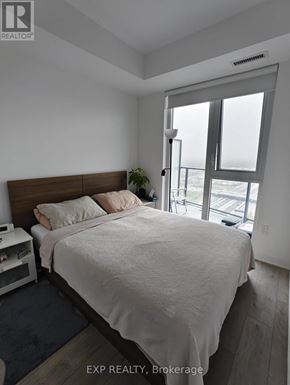 Toronto (Islington-City Centre West) condo for rent - A bedroom with a large bed and a window overlooking the street.