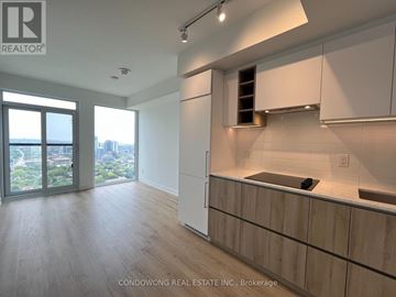 Toronto (Moss Park) condo for rent - A modern kitchen with white cabinets and a wooden countertop.