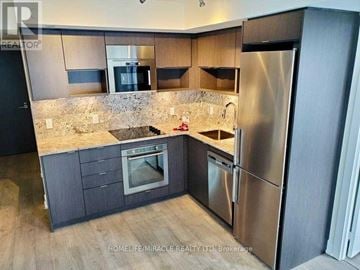 Toronto (Islington-City Centre West) condo for rent - A modern kitchen with a refrigerator, oven, and sink.