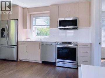 Vancouver apartment for rent - A kitchen with a refrigerator, oven, and microwave.