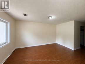 Toronto (Kennedy Park) townhouse for rent - A room with wooden floors and white walls, with a window on the left side.