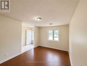 Toronto (Kennedy Park) townhouse for rent - A room with wooden floors and white walls, with a window and a door visible.