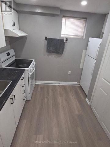 Brampton (Fletcher's Creek South) apartment for rent - A kitchen with white cabinets and a black countertop.