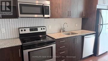 Toronto (Moss Park) condo for rent - A kitchen with a black stove top oven and a black microwave above it.